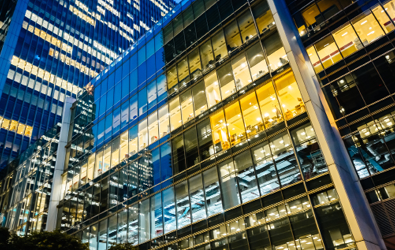 glass office building with blue and yellow lit areas