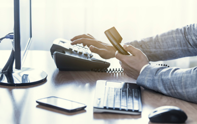 person at computer placing a call on a phone system