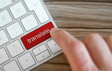 finger hovering over a red translate key part of a keyboard