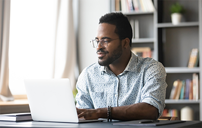 Person looking at a laptop screen while sitting at a desk
