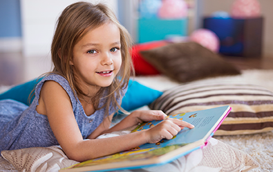 girl pointing to words on a page of a book