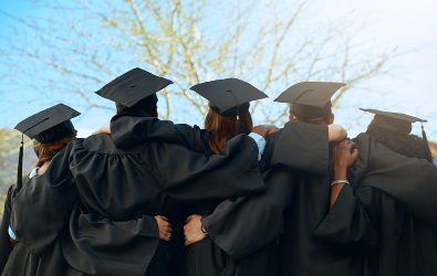 Graduates in graduation gowns and caps hugging each other with their backs faced to us