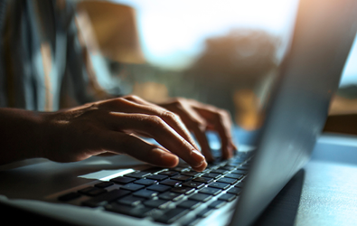 person typing on a laptop keyboard