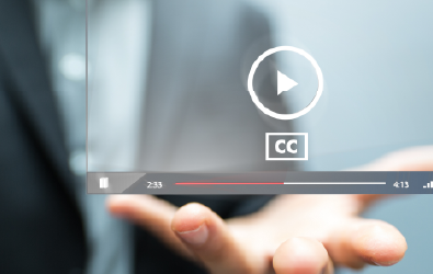 hand holding a paused video frame with closed captioning icon displayed